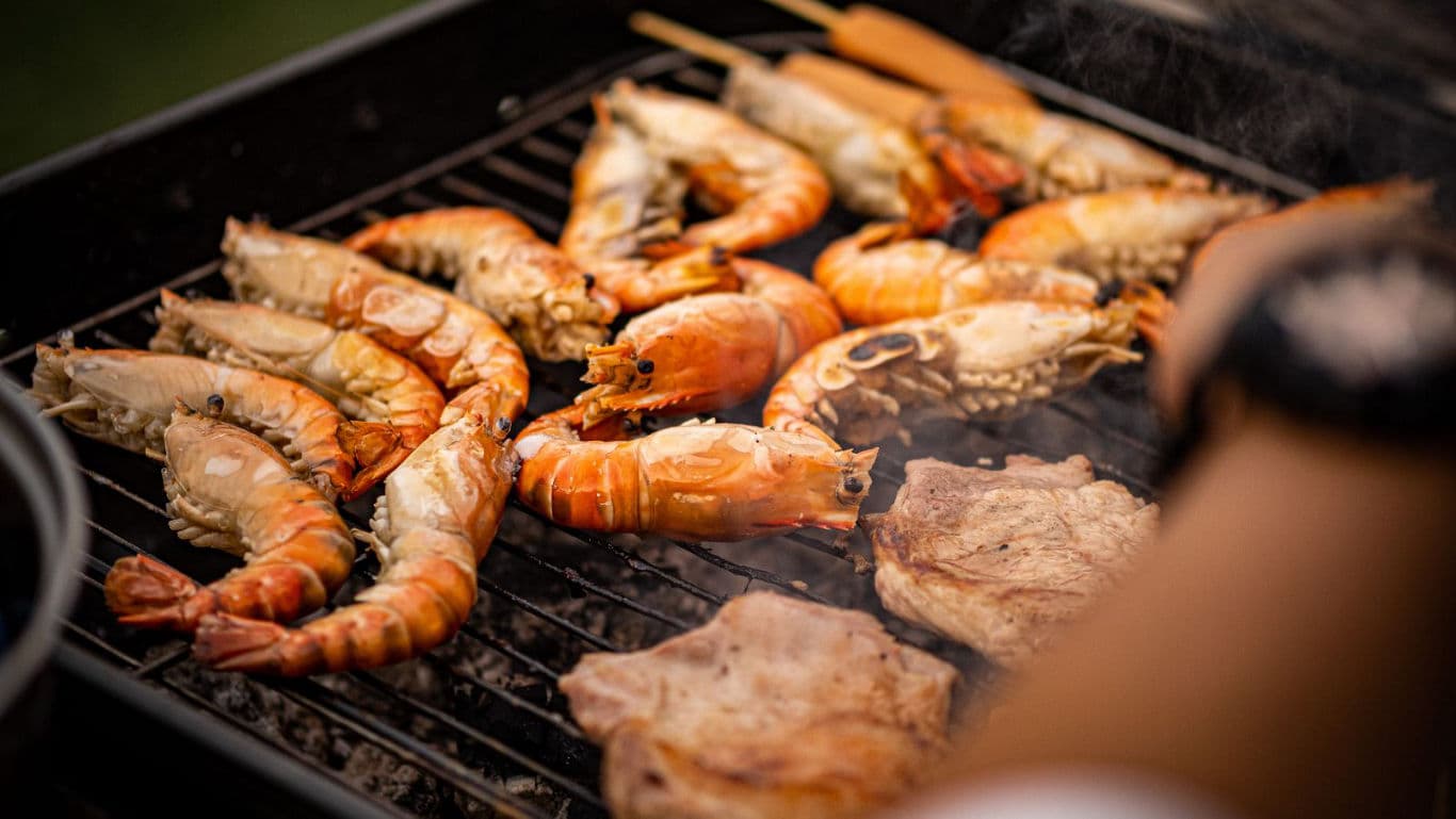 Grilled Prawns and Meat Cooking on Outdoor Barbecue