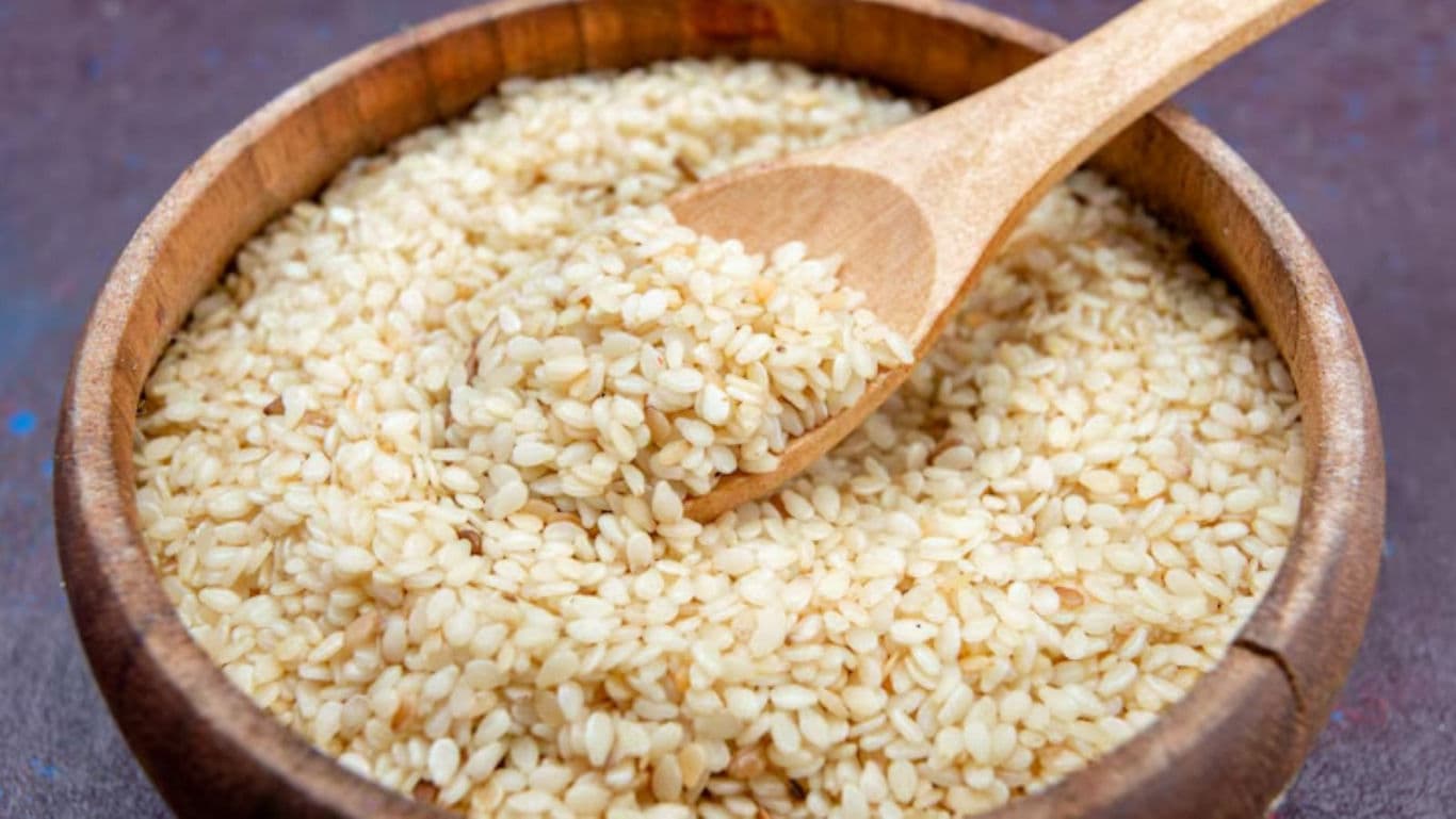 Wooden bowl of sesame seeds with spoon