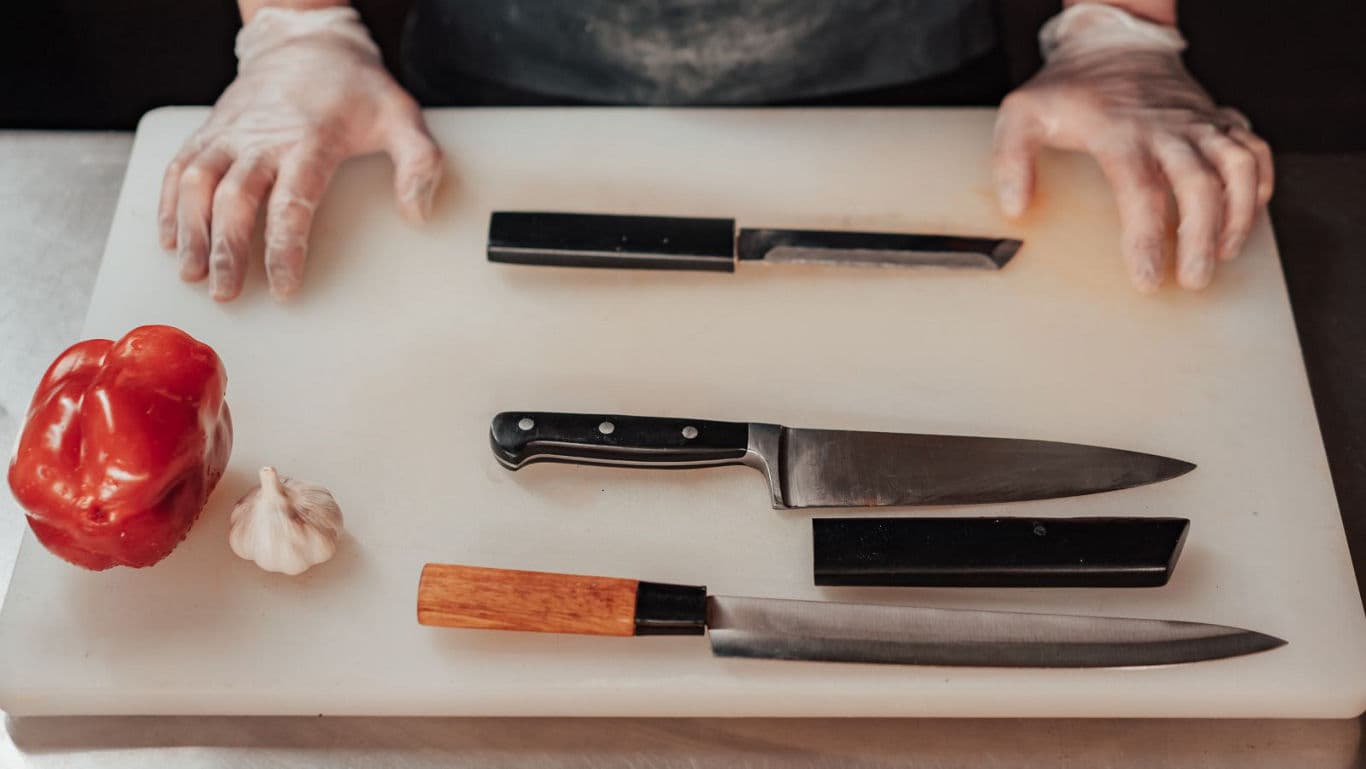 Chef preparing vegetables with assorted kitchen knives