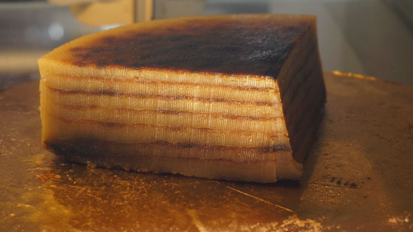 Layered cake slice on golden surface
