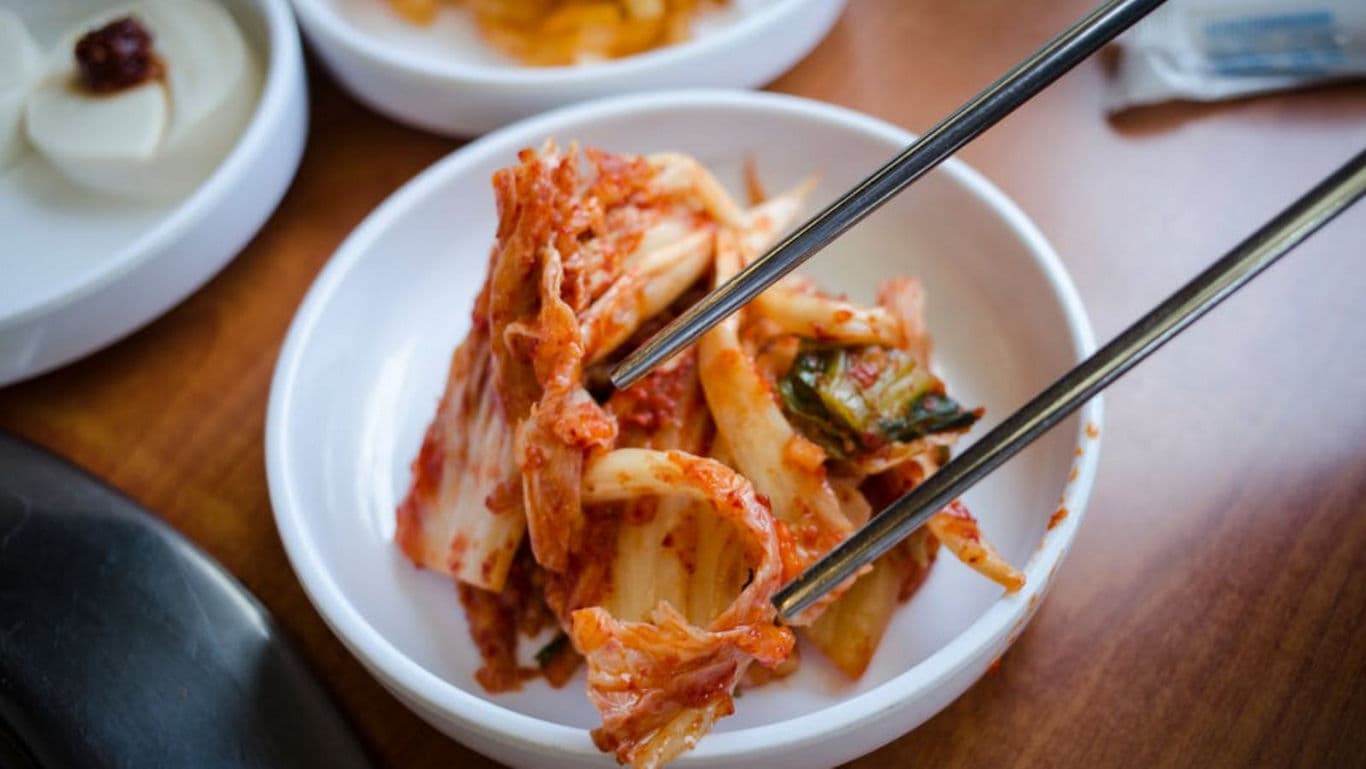 Chopsticks Picking Up Spicy Kimchi Dish