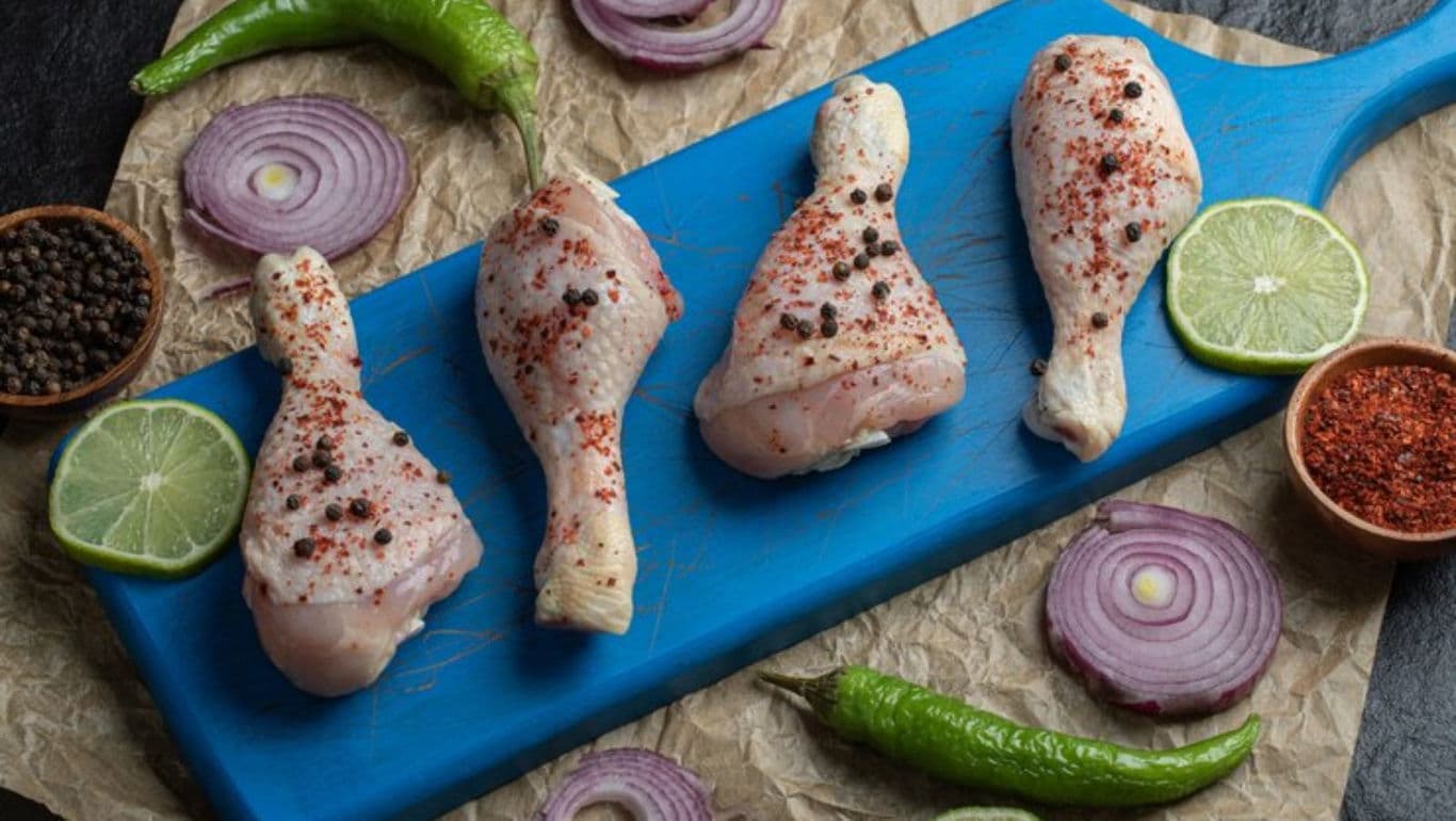 Raw chicken drumsticks with spices and vegetables