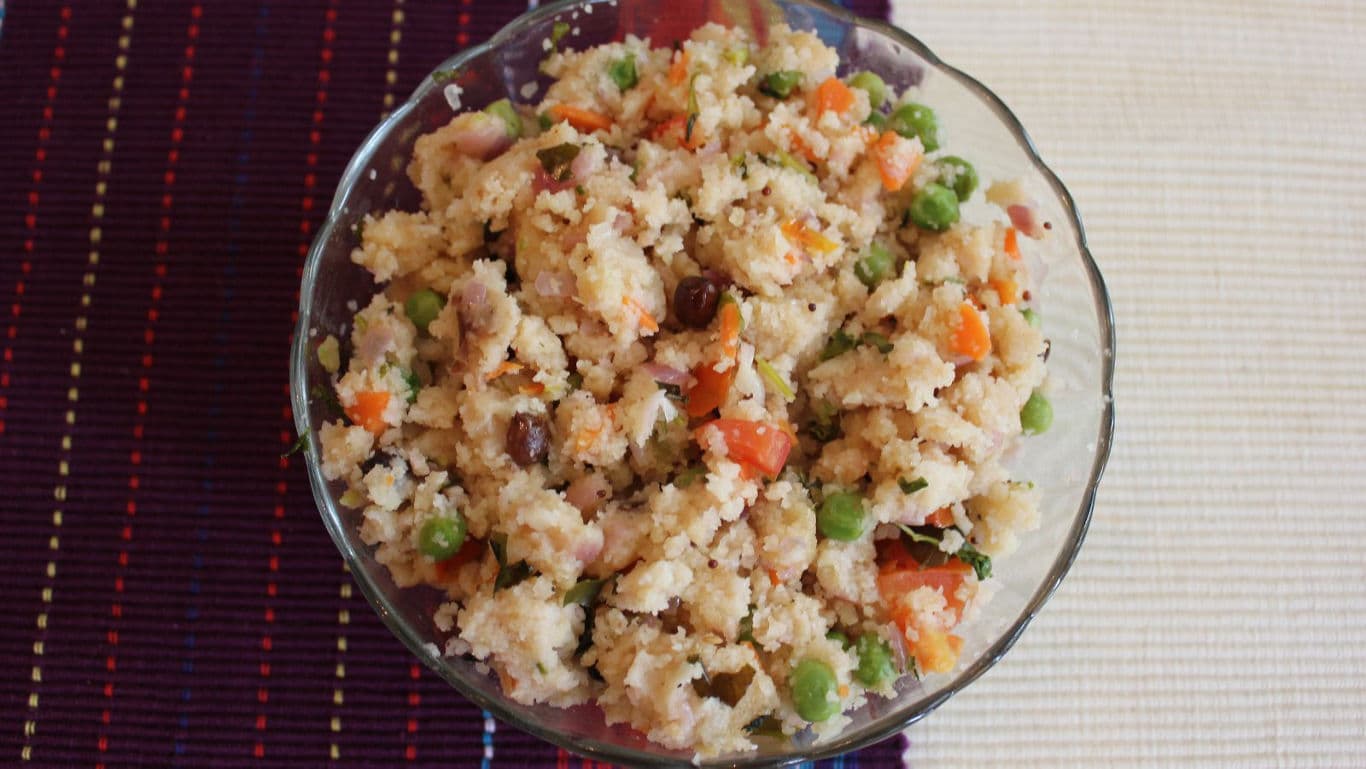 Vegetable upma in glass bowl on mat