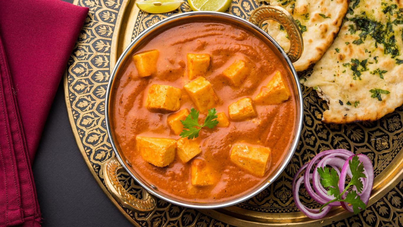Paneer curry with naan and garnishes