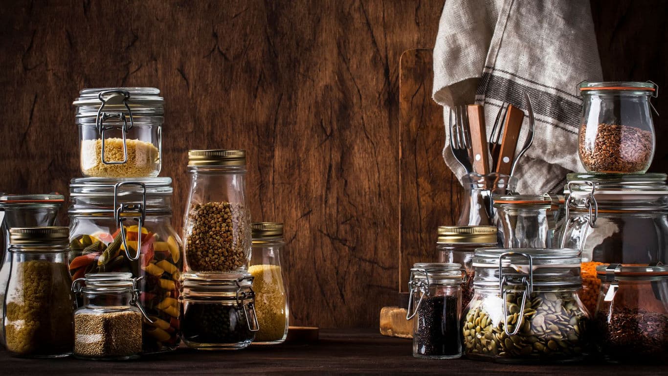 Assorted pantry jars on rustic wooden table