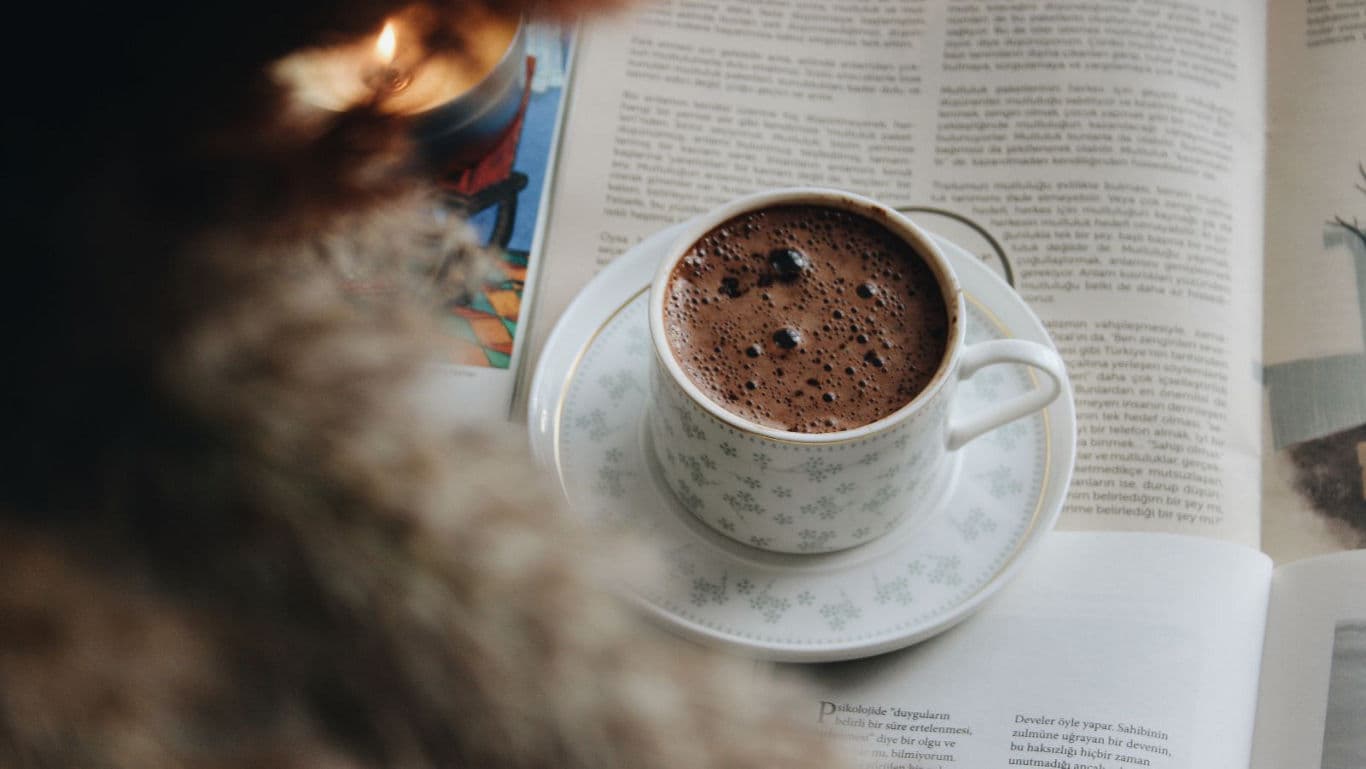 Cup of coffee on open book