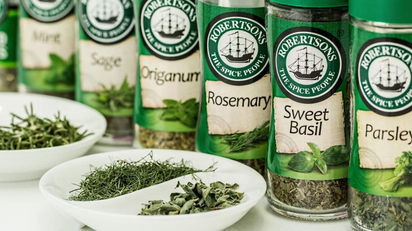 Assorted Robertson's Spice Bottles and Fresh Herbs Display
