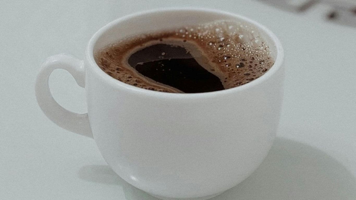 White ceramic cup filled with black coffee