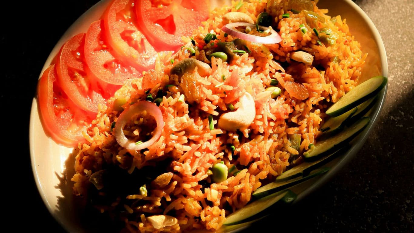 Spiced rice pilaf with sliced tomatoes and cucumbers