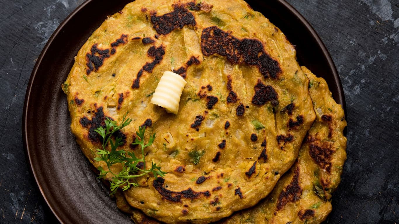 A plate of thalipeeth with butter
