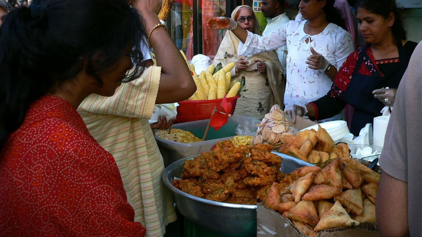 Crowded street food stall serving Indian snacks