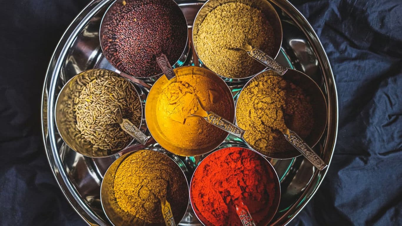 Assorted colorful spices in metal bowls