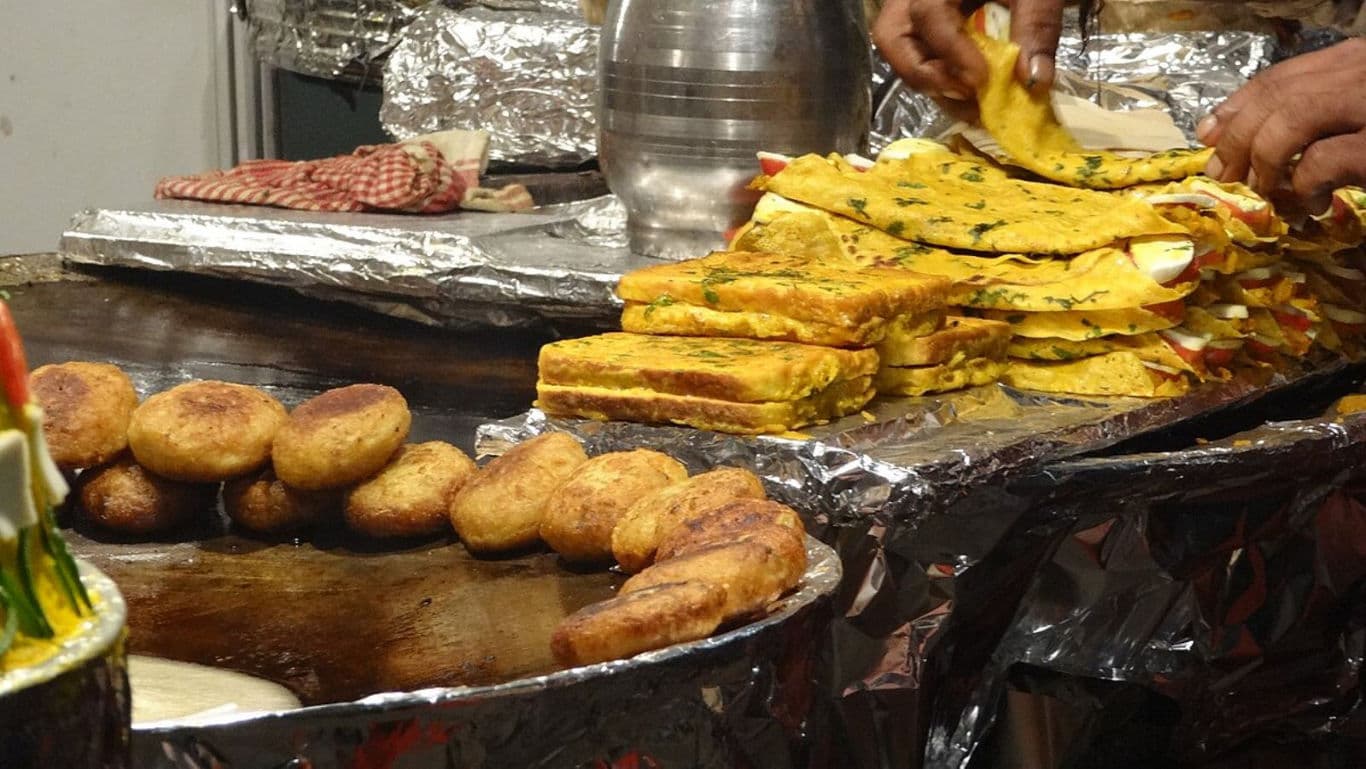 Street vendor preparing Indian stuffed bread and snacks