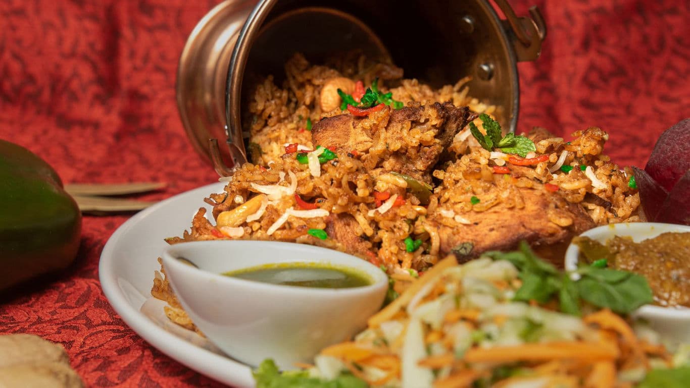 Spiced rice dish with sides and garnish