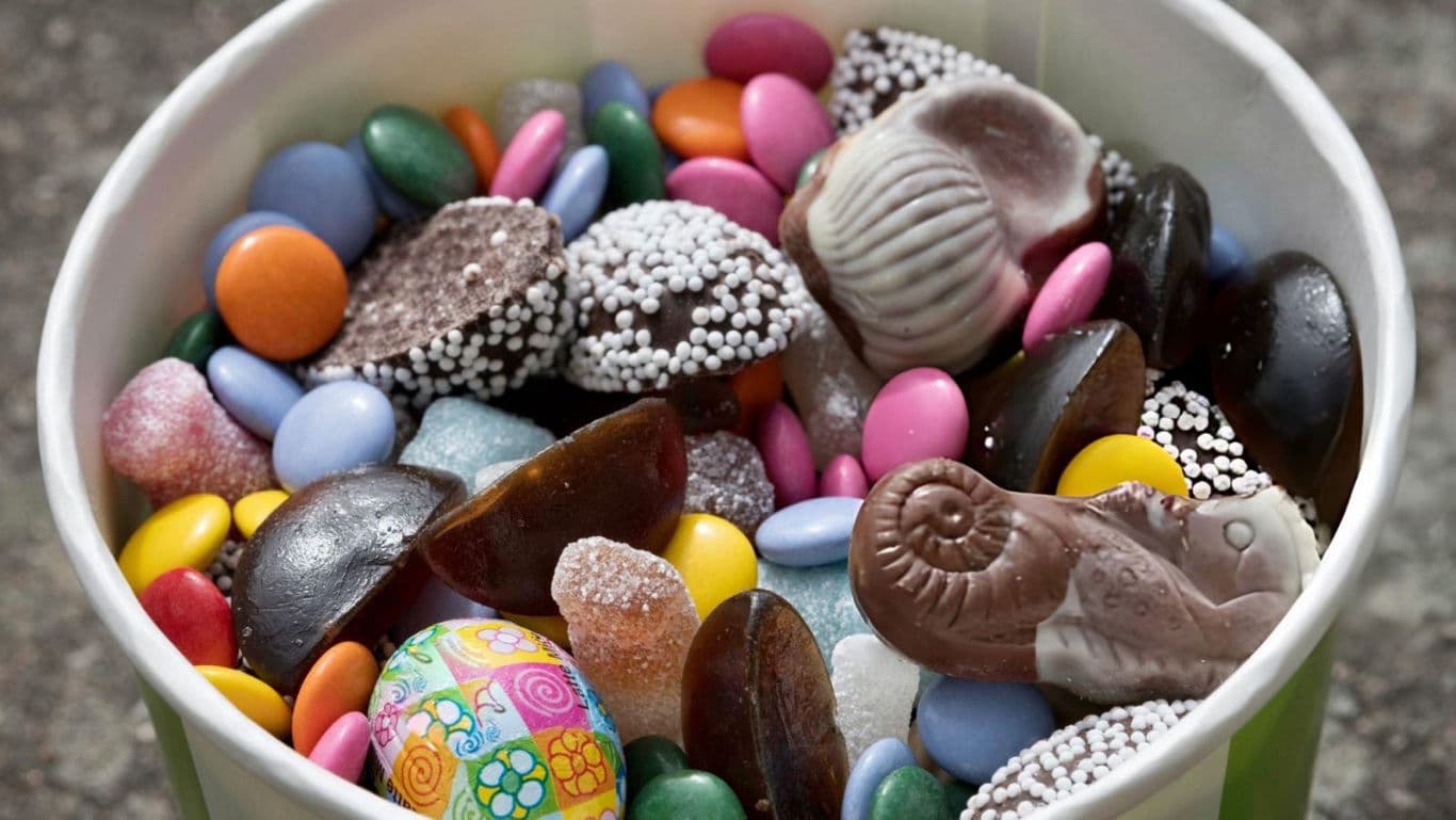 Assorted colorful candies in a paper cup