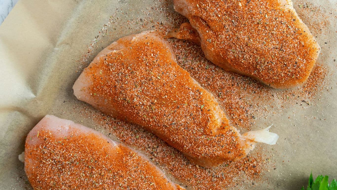 Raw chicken breasts coated with dry spice rub