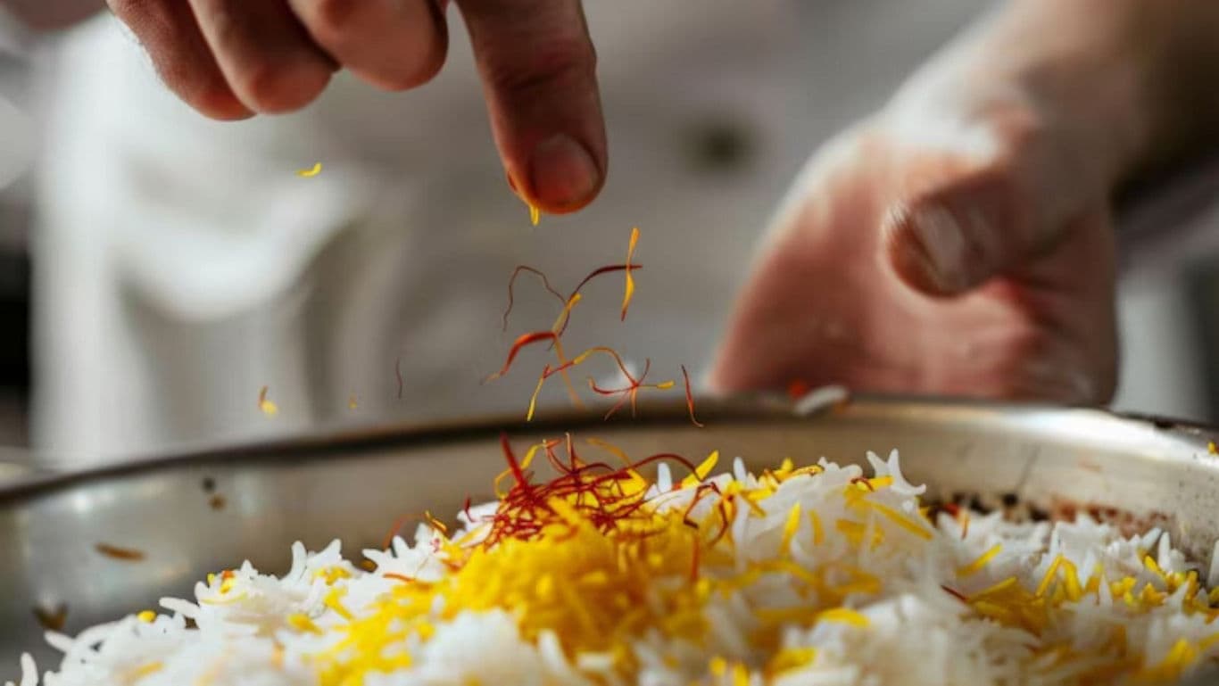 Chef Garnishing Saffron Rice in Kitchen