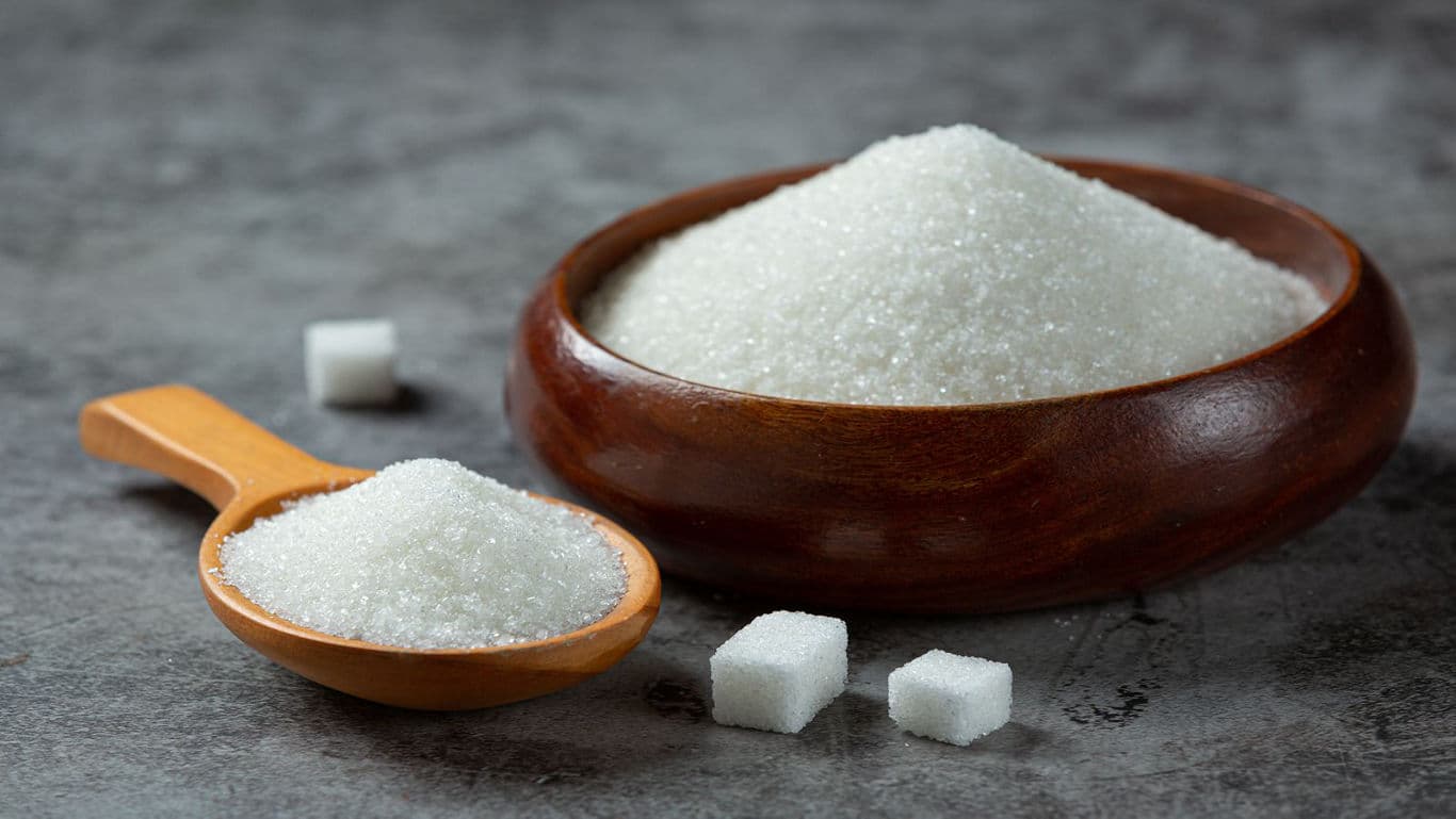 Granulated sugar in wooden bowl and spoon