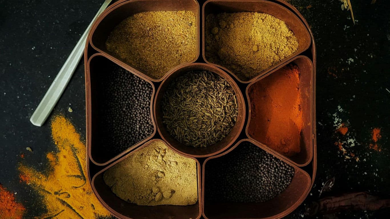 Assorted Indian spices in wooden spice box overhead