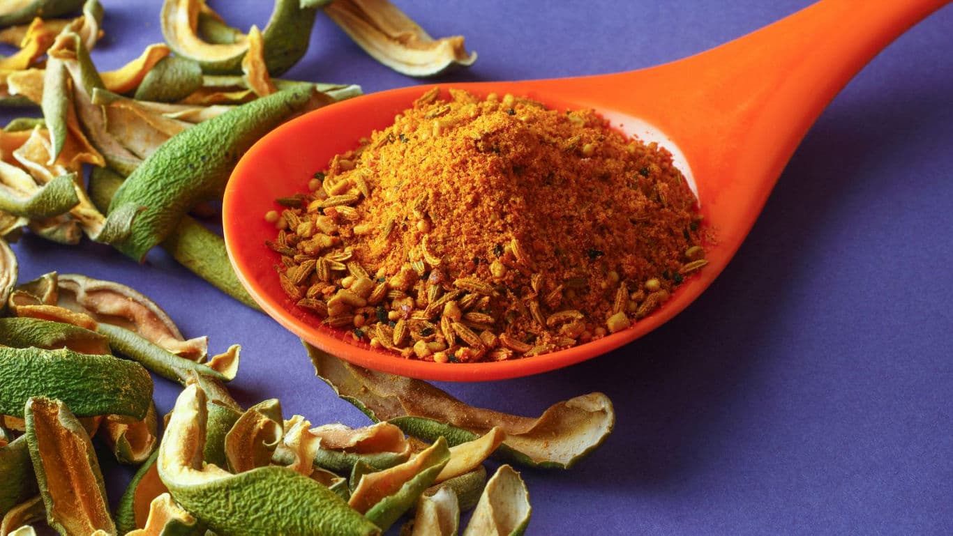 Spice blend and dried herbs on orange spoon