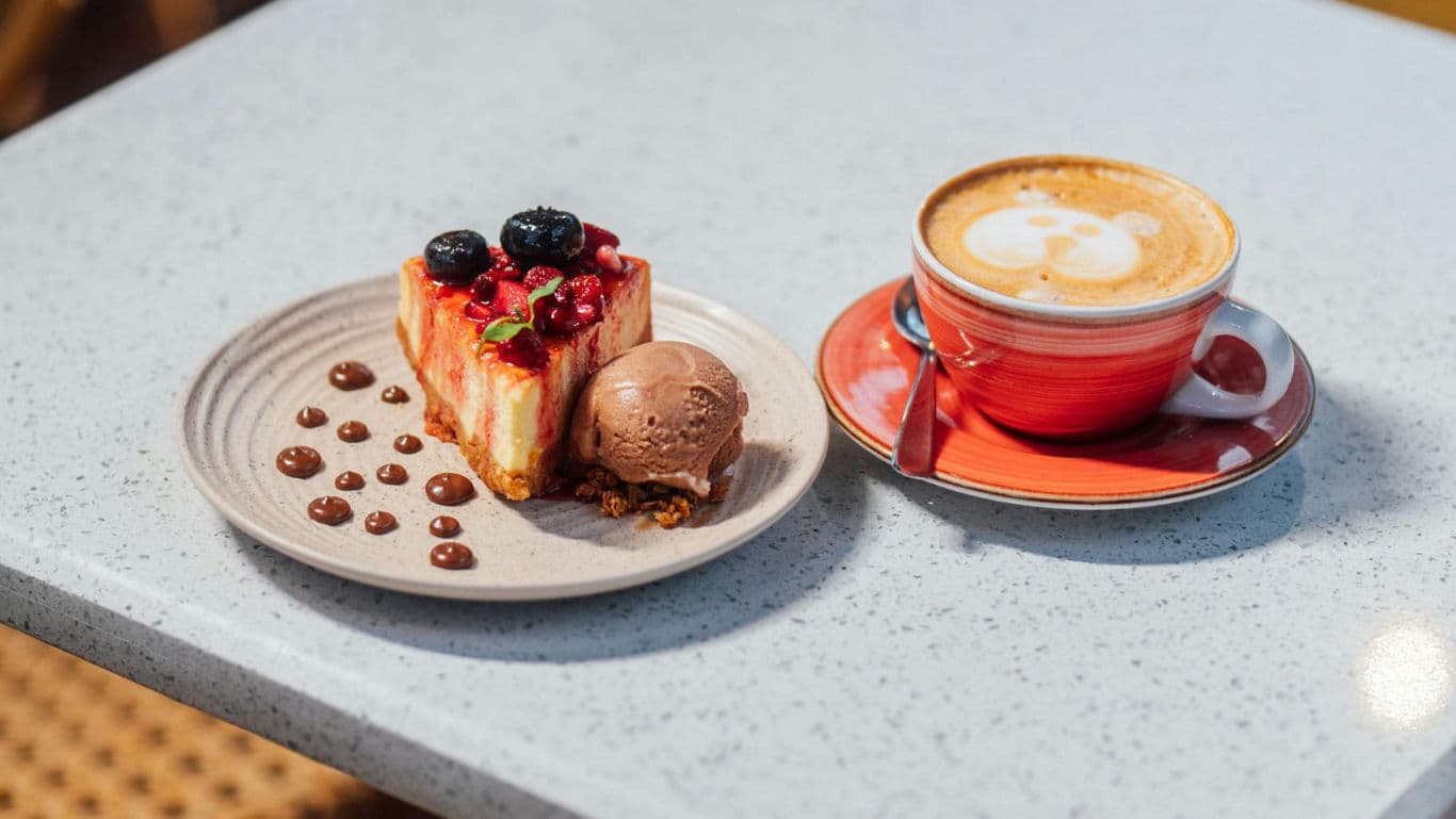 Berry cheesecake and cappuccino on café table