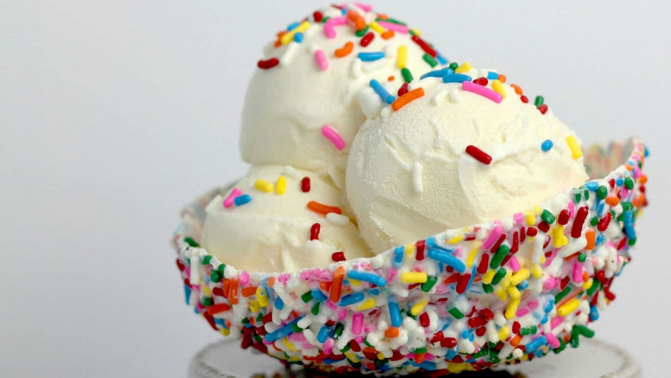 Vanilla ice cream scoops in sprinkle-coated bowl