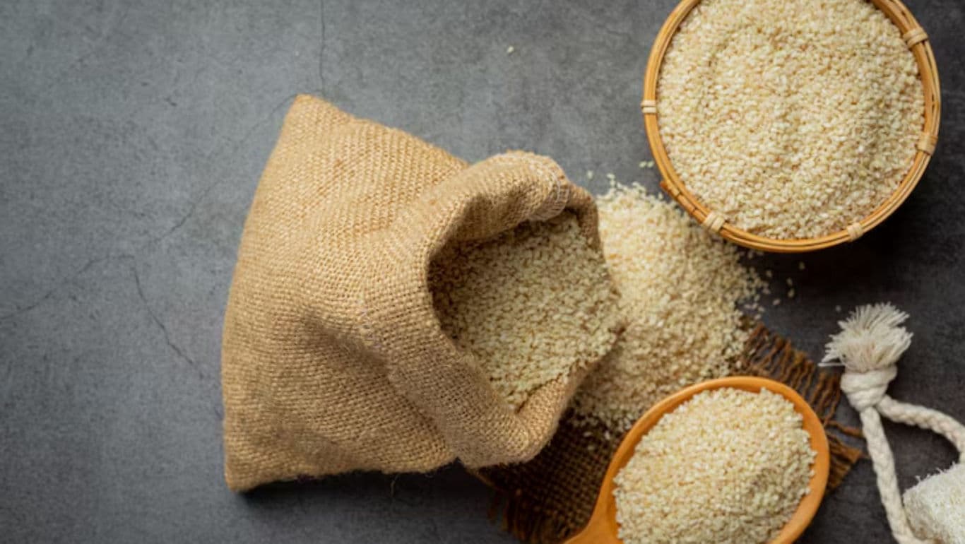 Raw sesame seeds in burlap sack and wooden bowl