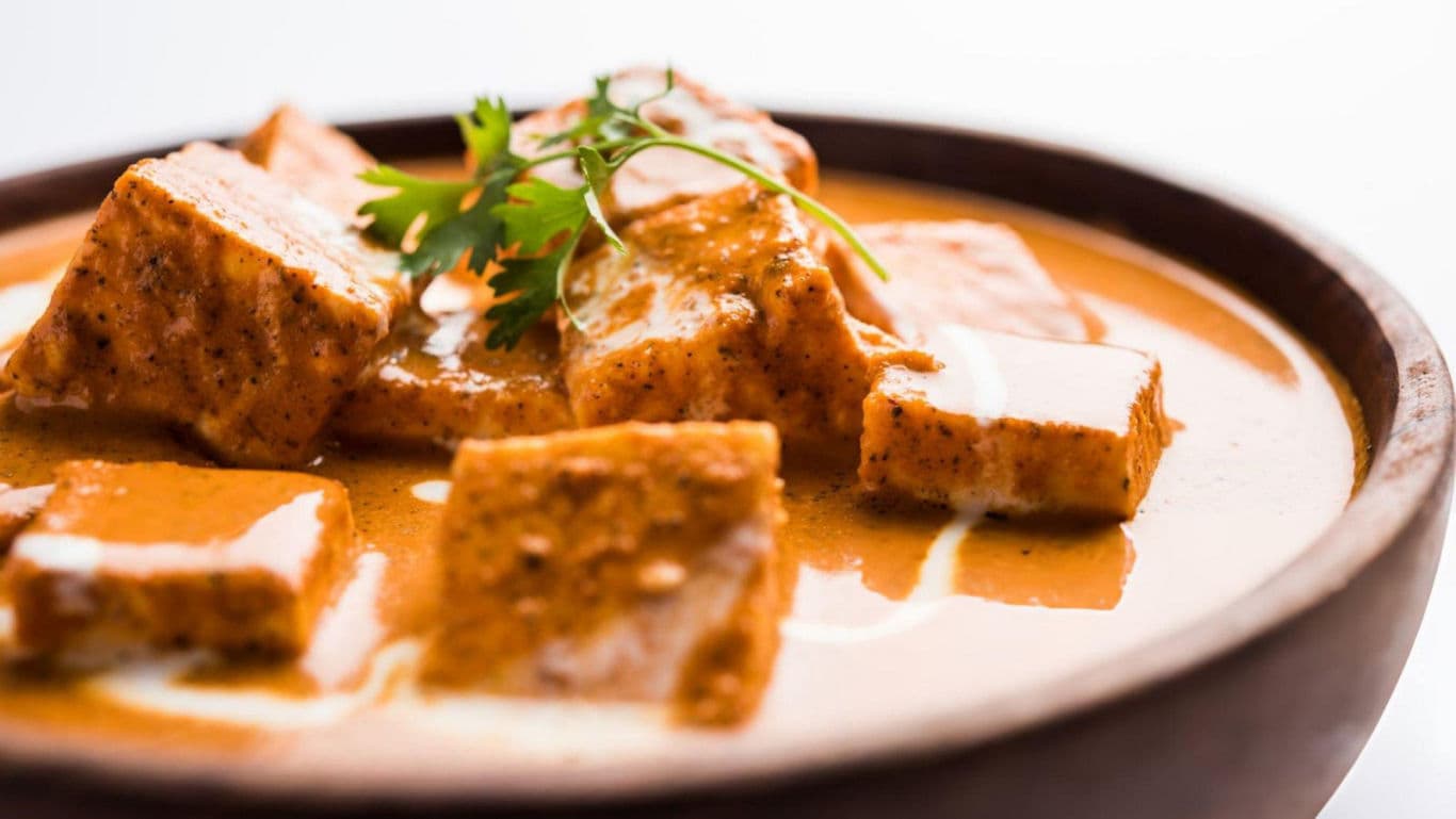 Creamy paneer curry in wooden bowl