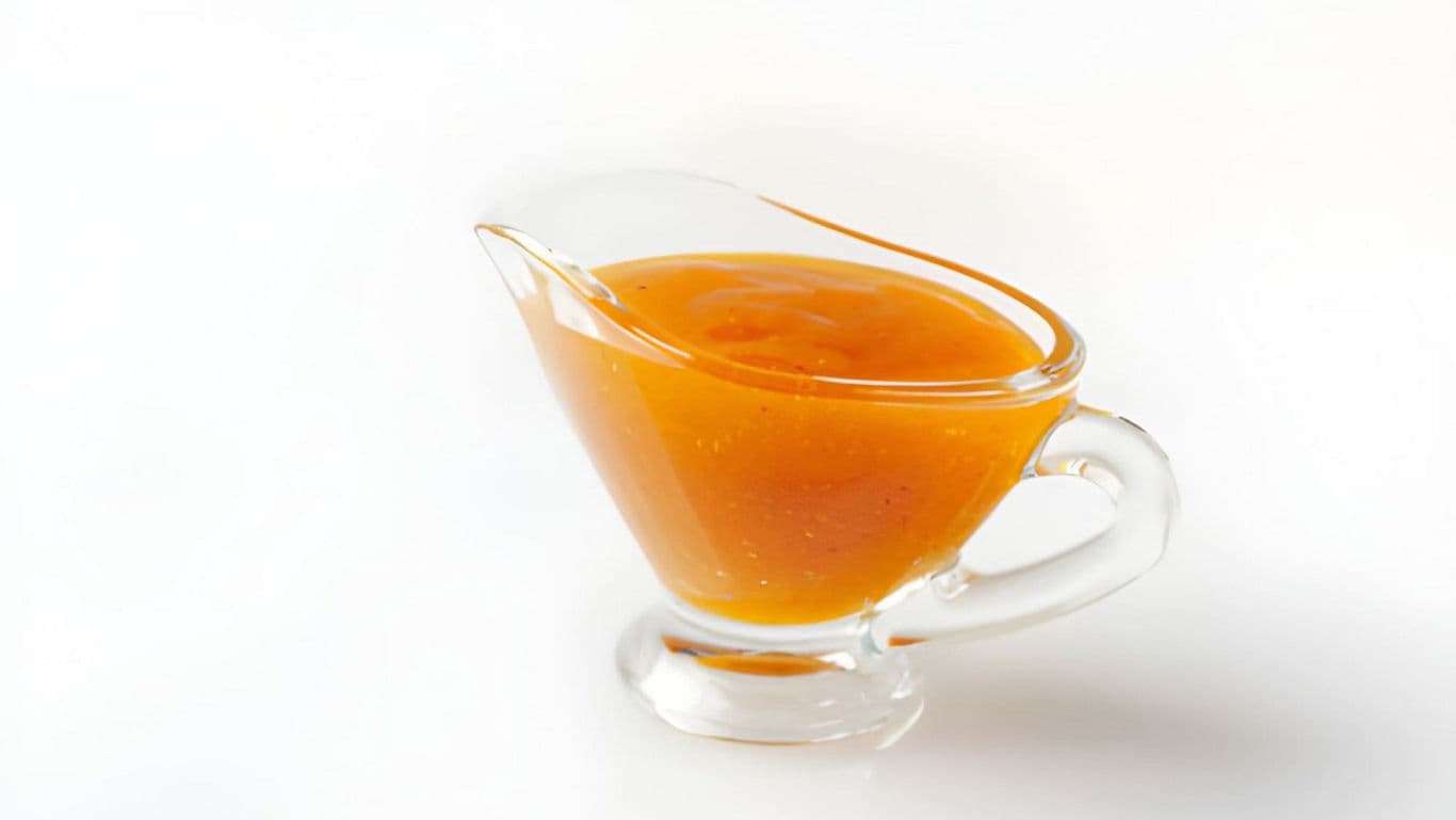 Glass gravy boat with orange sauce