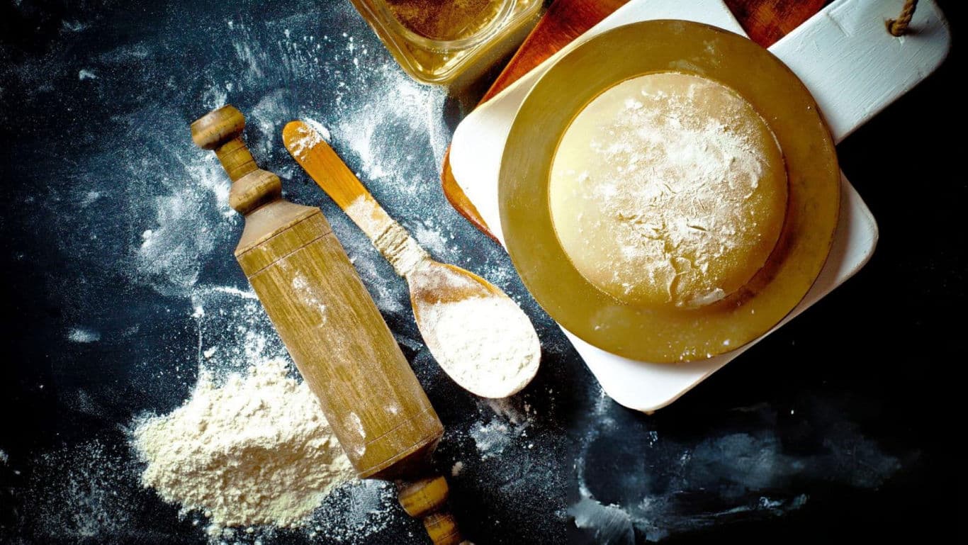 Rustic baking setup with dough and flour