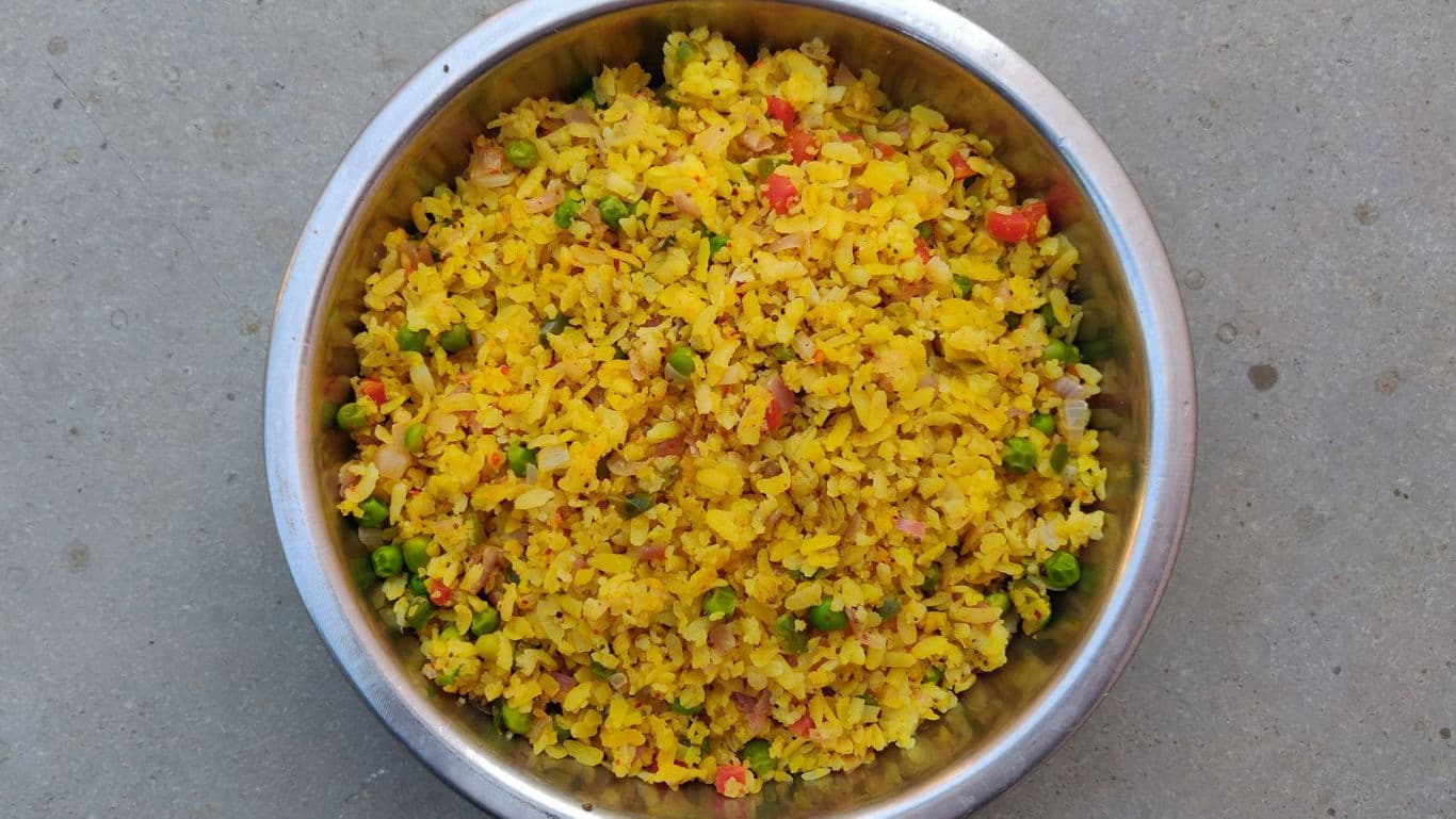 Colorful poha dish in stainless steel bowl