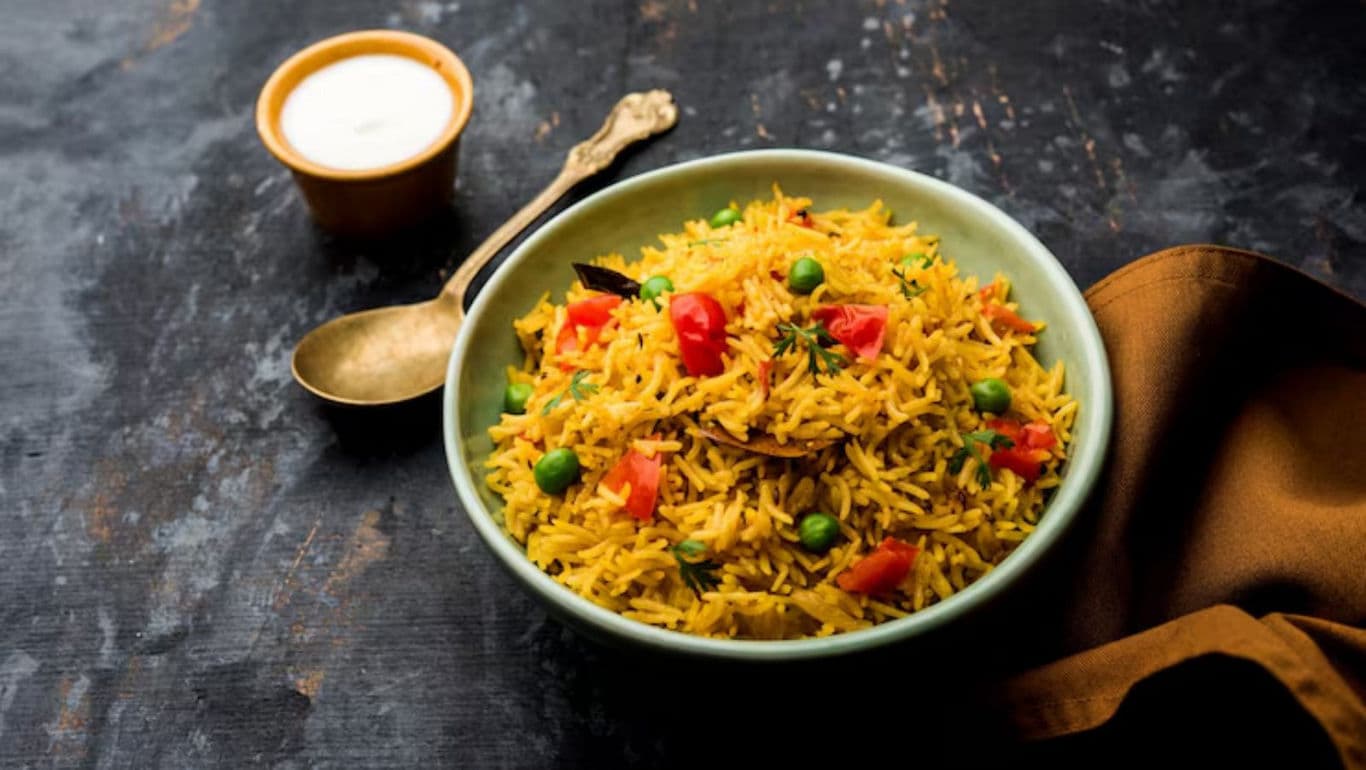 Vegetable biryani served with yogurt dip