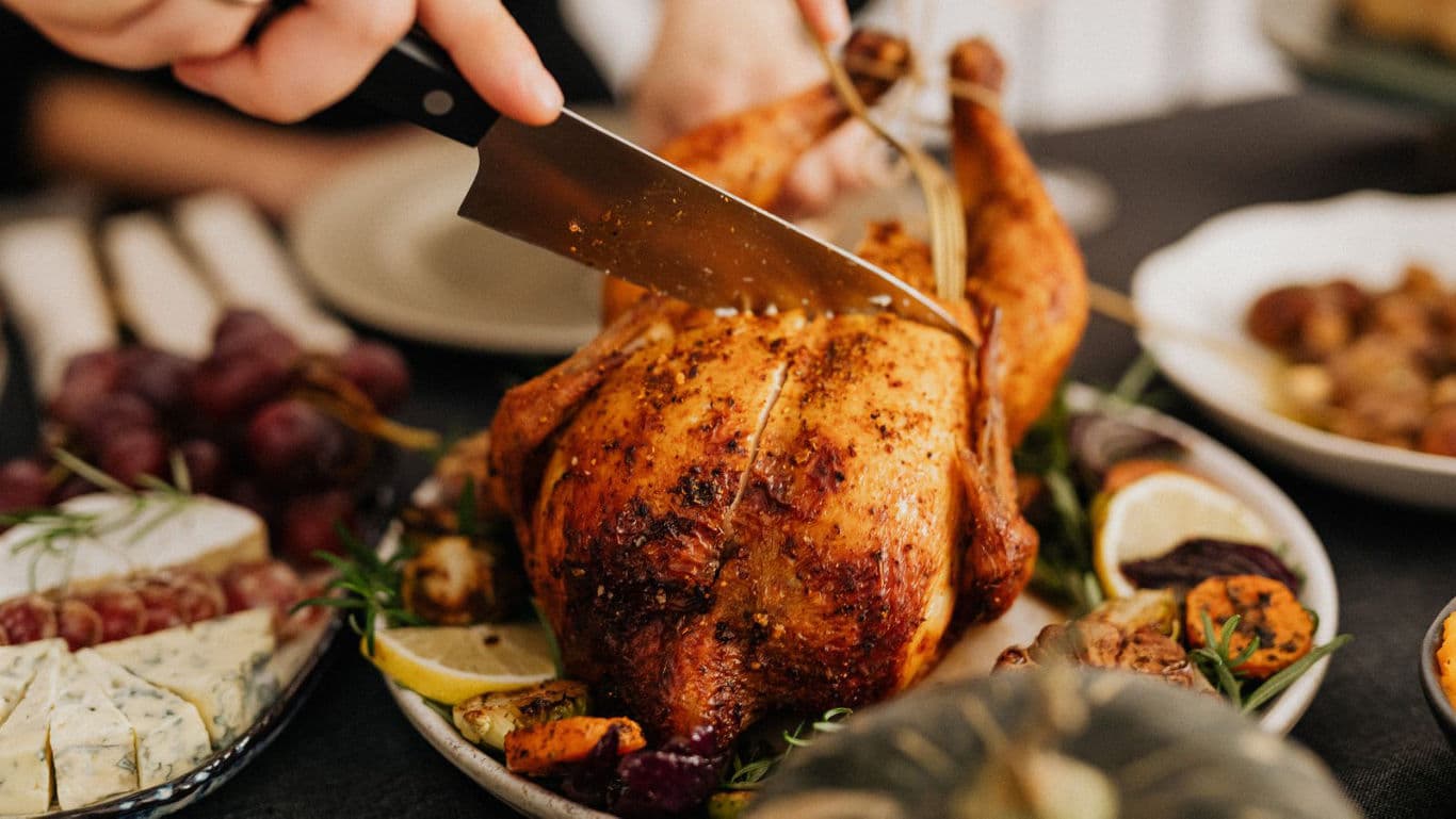 Carving Roast Chicken at Festive Dinner Table