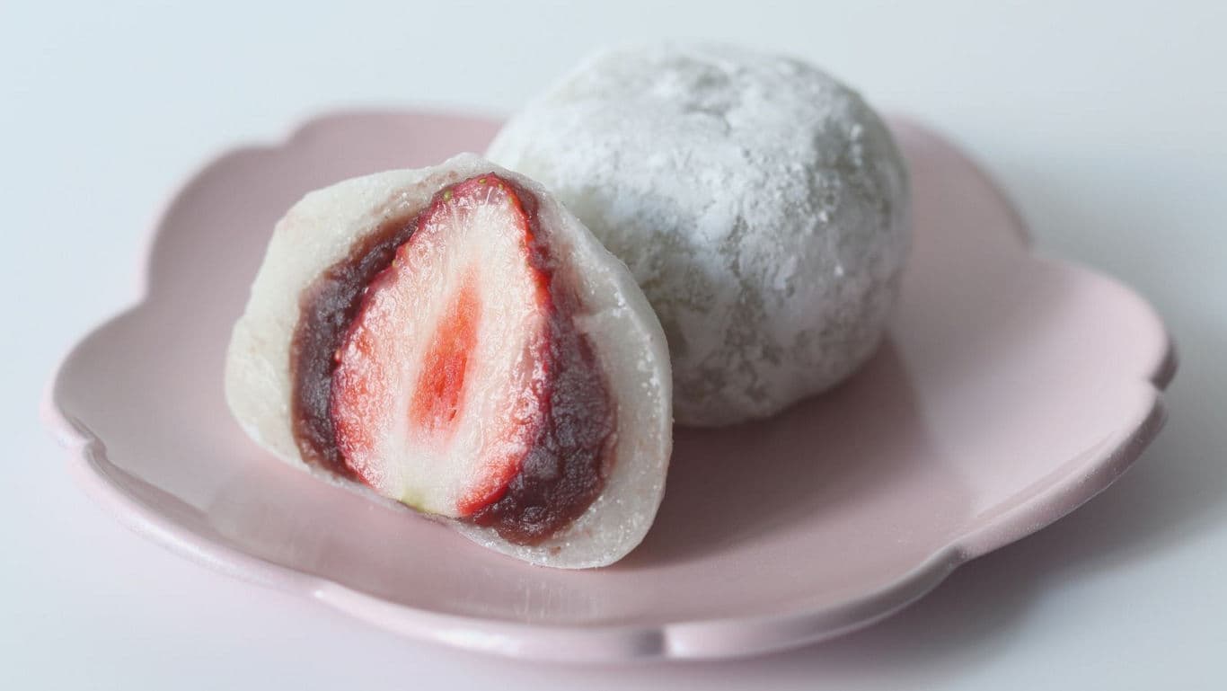 Strawberry-filled mochi on pink plate