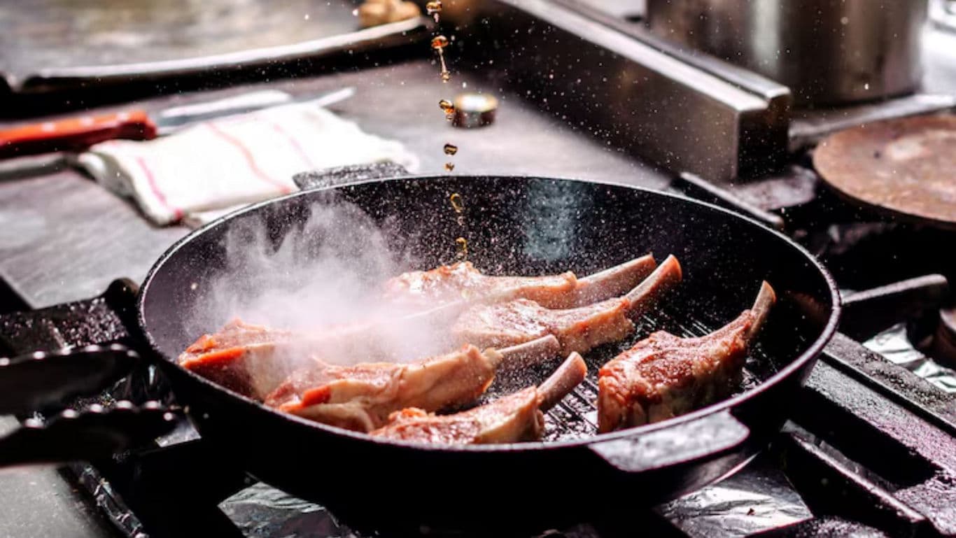 Sizzling lamb chops searing in hot skillet