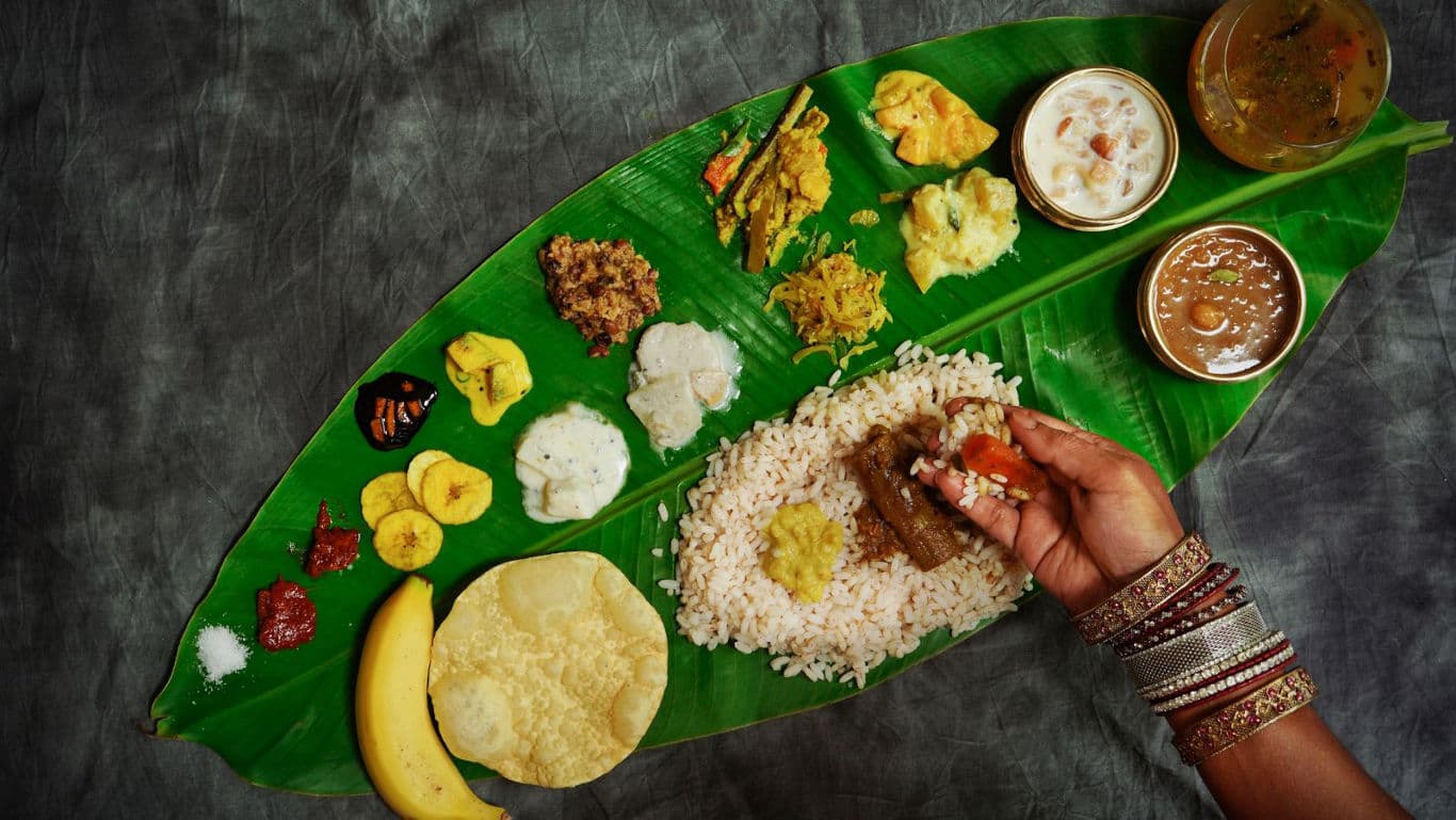 Traditional Onam Sadya feast served on a banana leaf with various Kerala dishes.