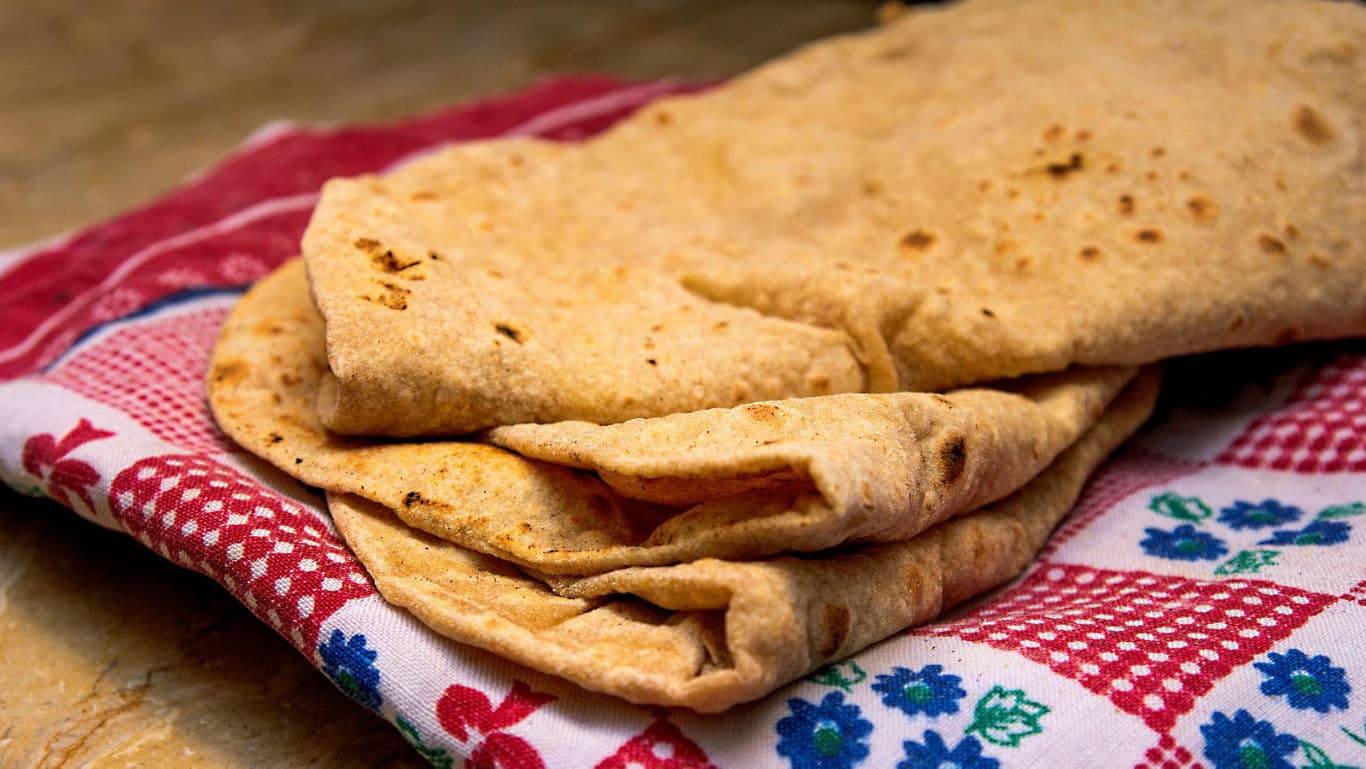 Freshly cooked flatbreads on patterned cloth