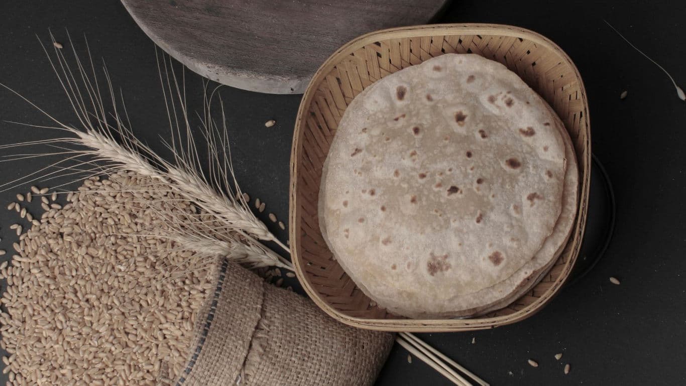 Whole wheat rotis with wheat grains.