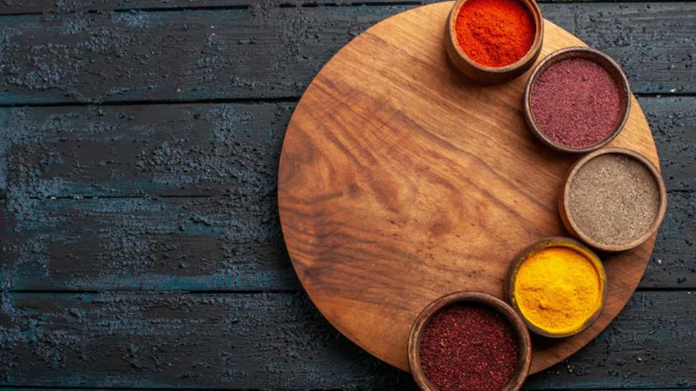Wooden platter with colorful spice bowls