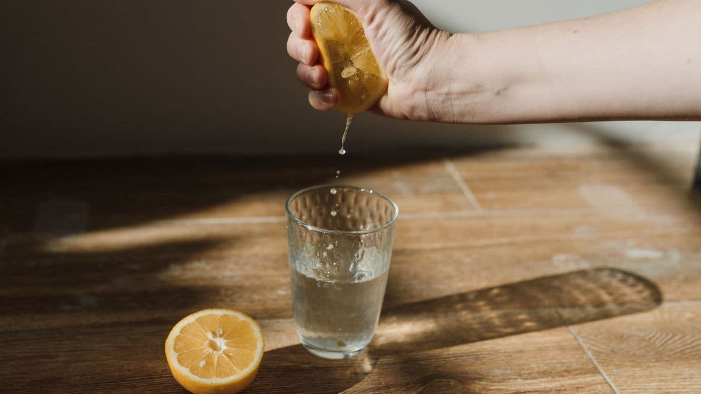 Hand squeezing lemon into glass