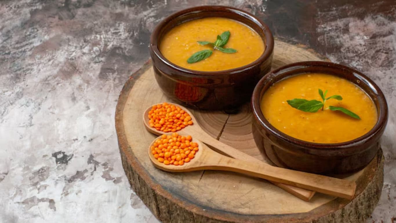 Two bowls of lentil soup with garnish