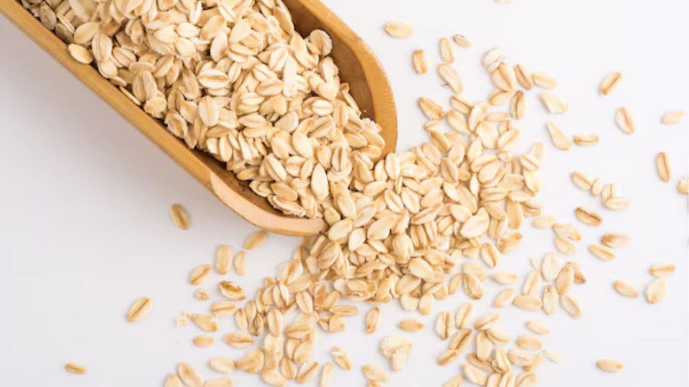 Wooden scoop with rolled oats spilling