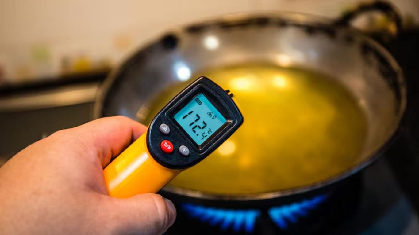 Handheld thermometer measuring hot liquid temperature