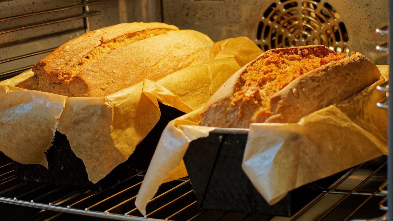 Freshly baked loaves of bread in oven trays