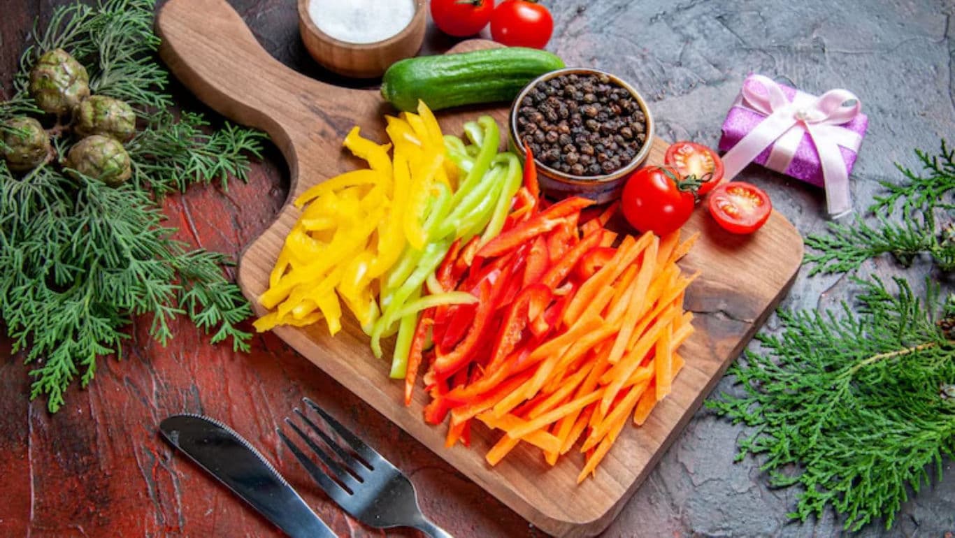 Colorful sliced peppers on wooden board