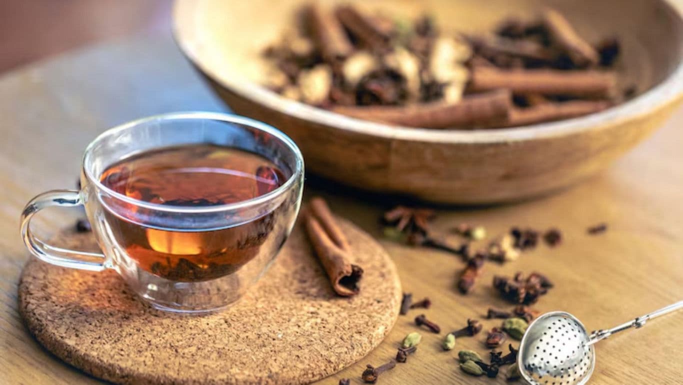 Glass cup of spiced tea with cinnamon