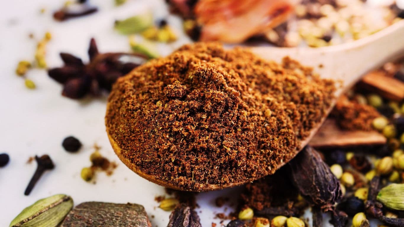 Wooden spoon with ground spices and herbs