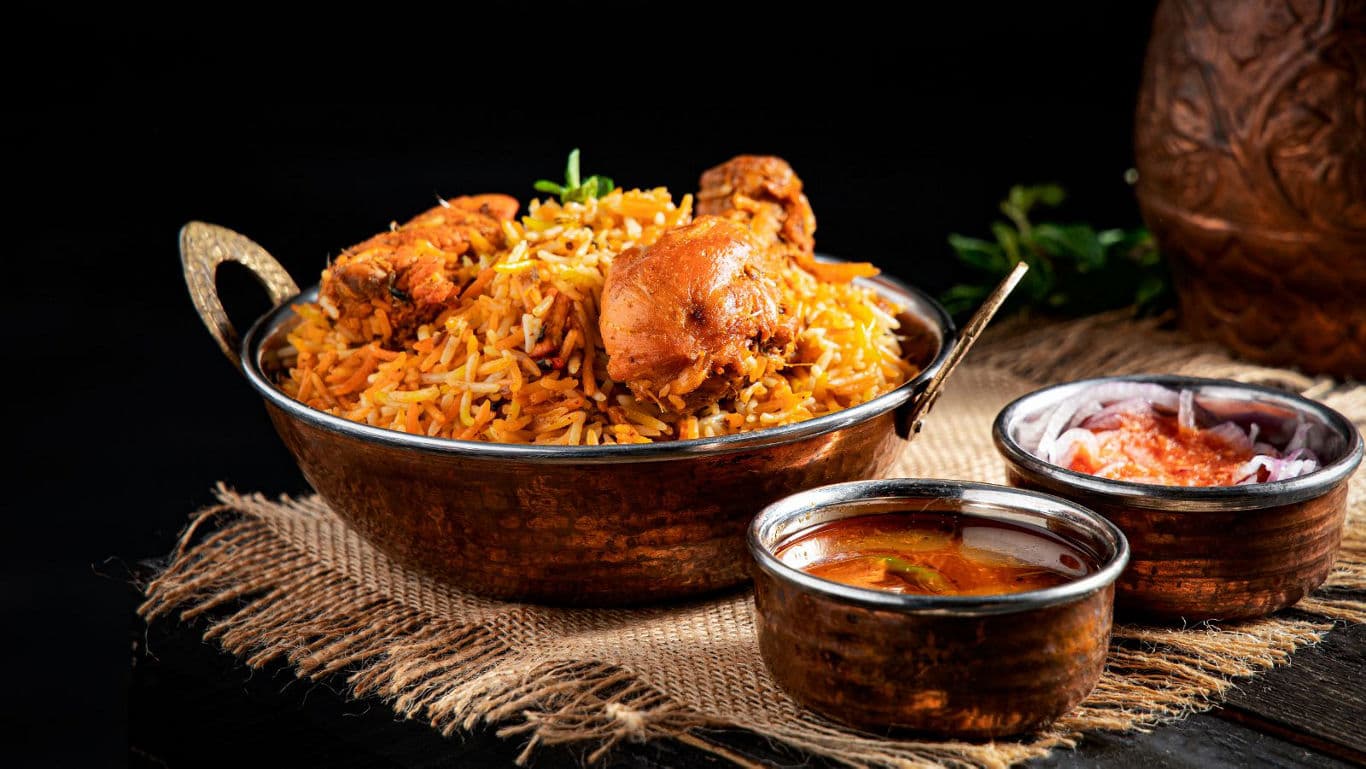 Traditional chicken biryani with side dishes