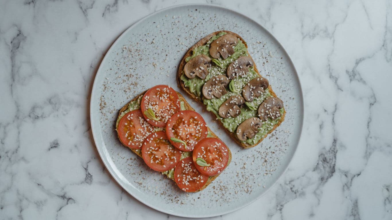 A variety of vegan breakfast dishes, including toast, smoothies, and savoury pancakes